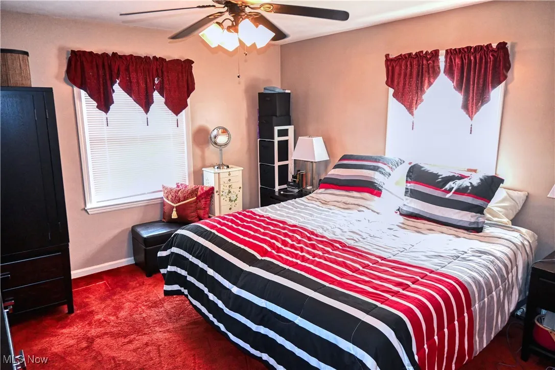Bedroom featuring a ceiling fan and dark carpet