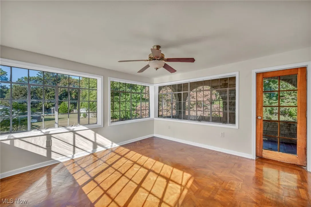 Unfurnished sunroom with baseboards