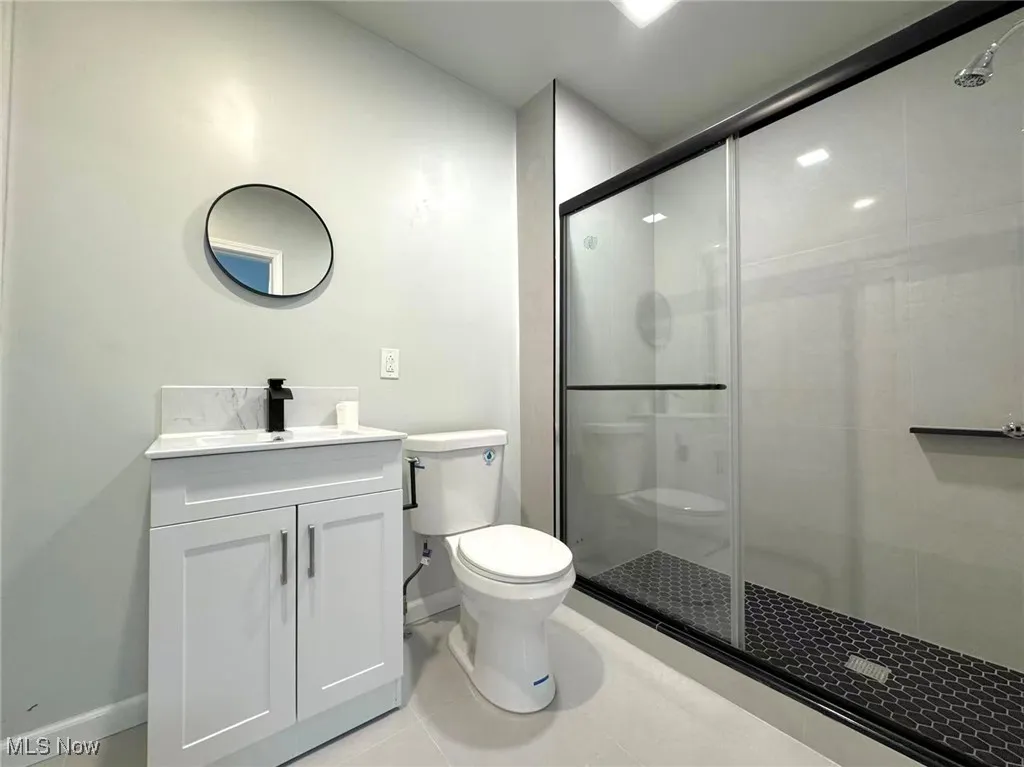 Bathroom with a stall shower, vanity, and light tile patterned floors