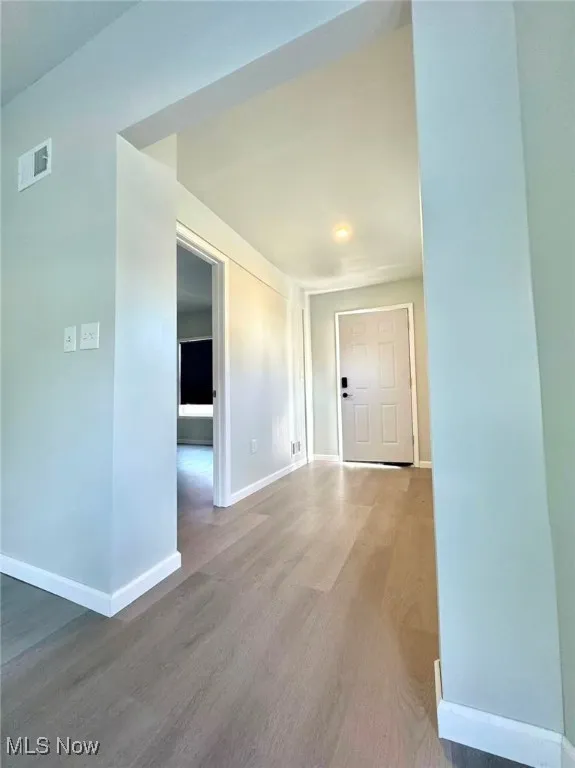 Hall with baseboards and wood finished floors