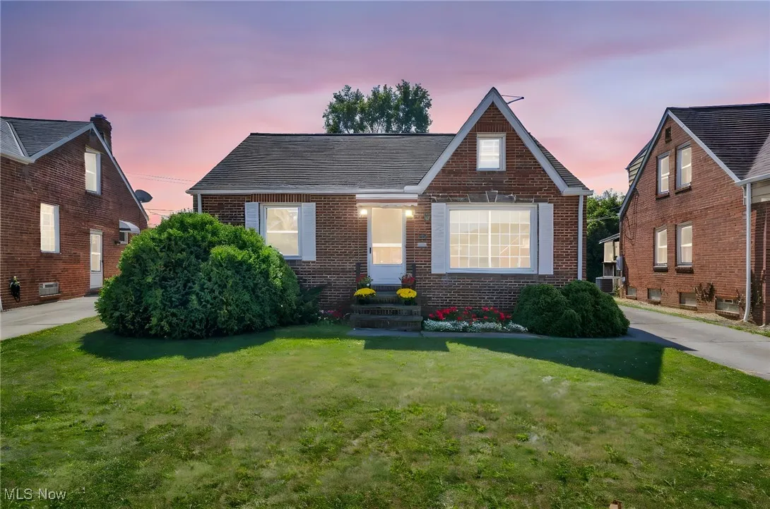 View of front of home featuring brick siding and a yard