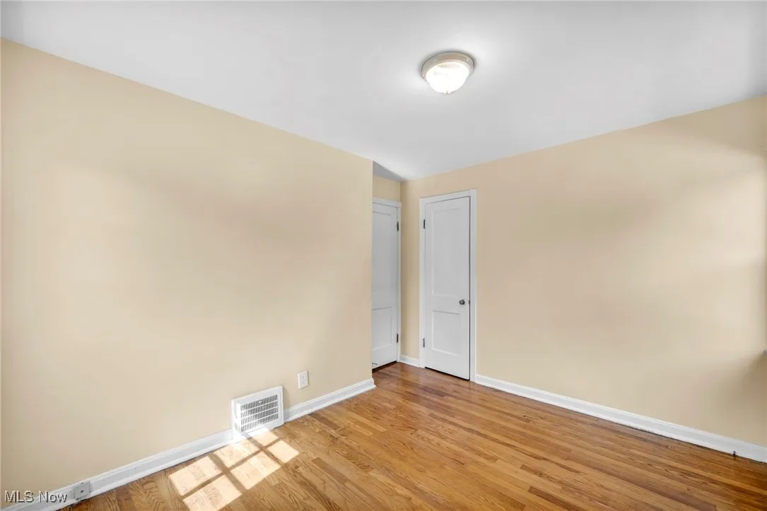 Spare room featuring baseboards and wood finished floors