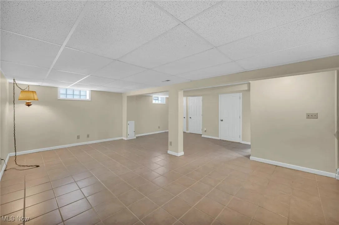 Below grade area with light tile patterned floors and a paneled ceiling