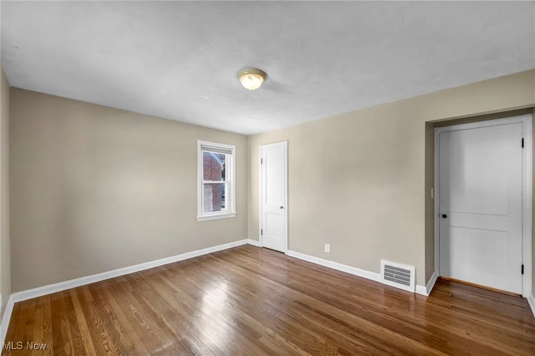 Unfurnished bedroom featuring wood finished floors and baseboards
