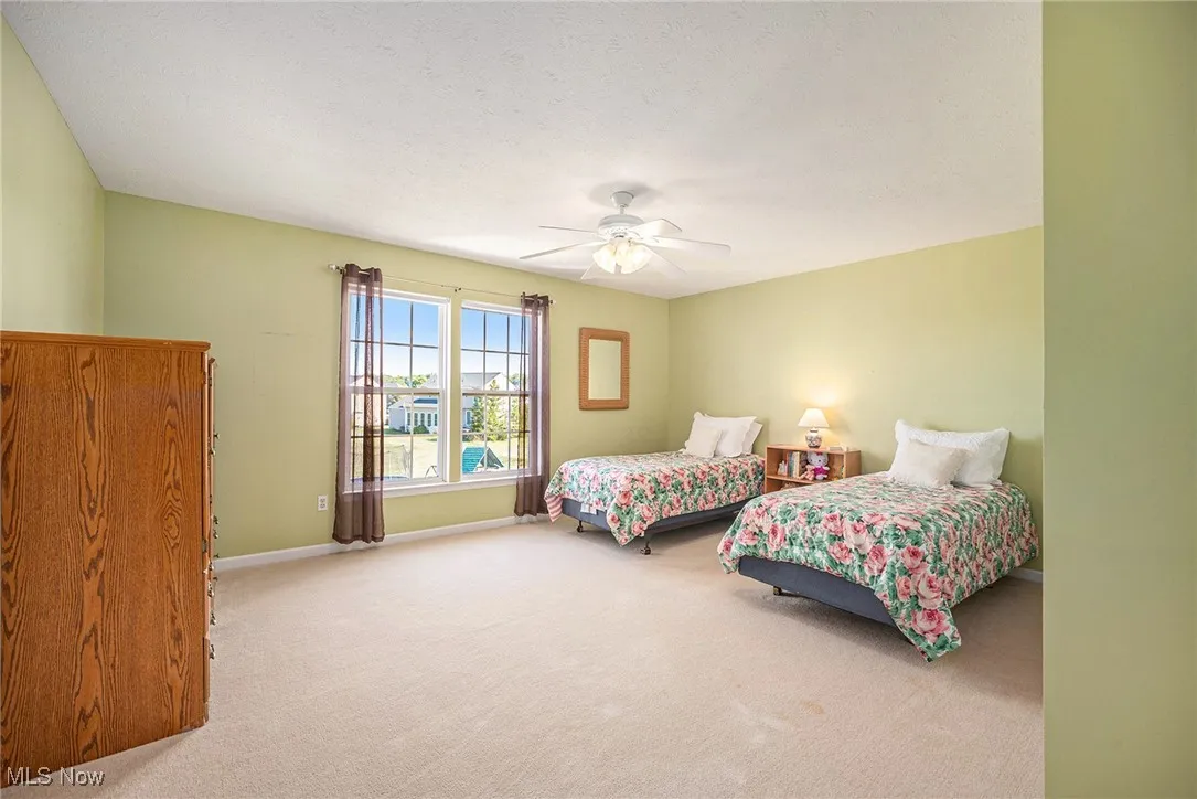 Bedroom featuring carpet floors, a ceiling fan, and a textured ceiling