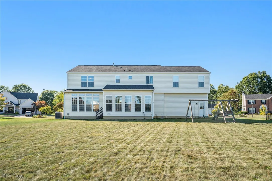 Back of house featuring a yard and a playground