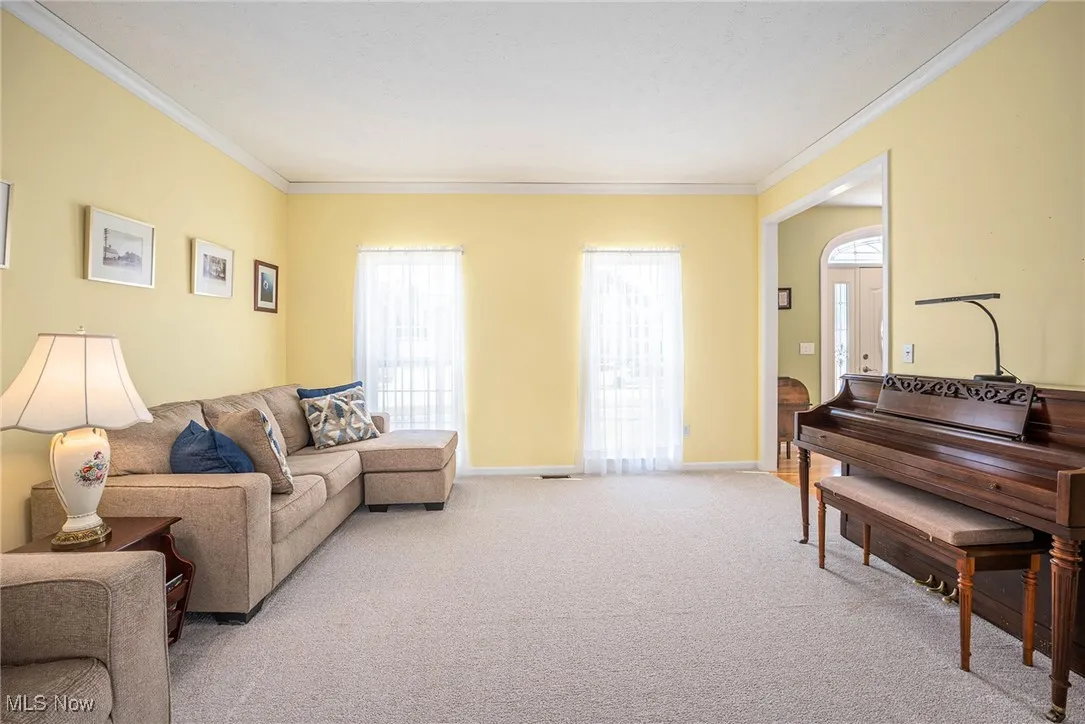 Living room with plenty of natural light, ornamental molding, and carpet flooring