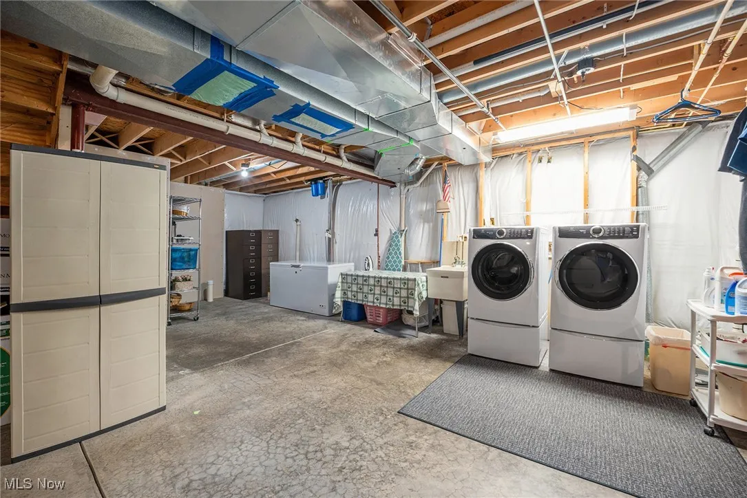 Unfinished basement with washing machine and clothes dryer