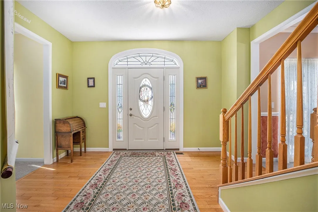 Entrance foyer with light wood-type flooring and stairs