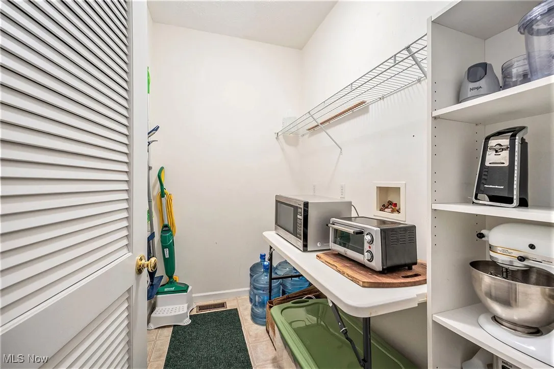 Laundry area featuring hookup for a washing machine and light tile patterned flooring
