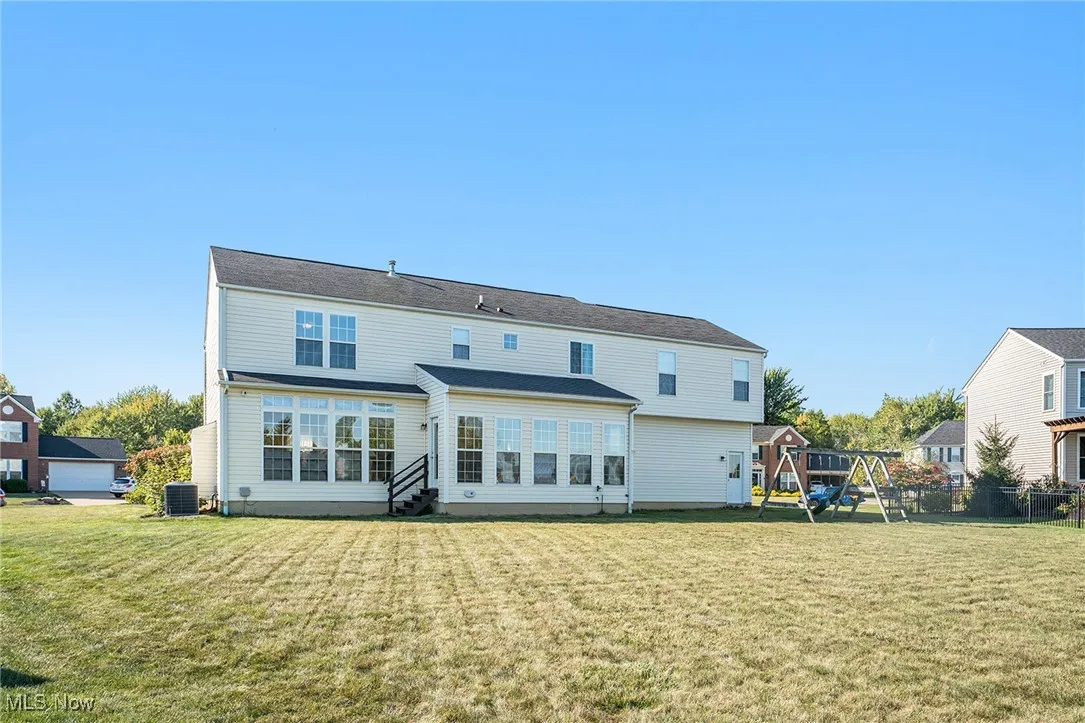 Back of property featuring a playground, a yard, and a patio