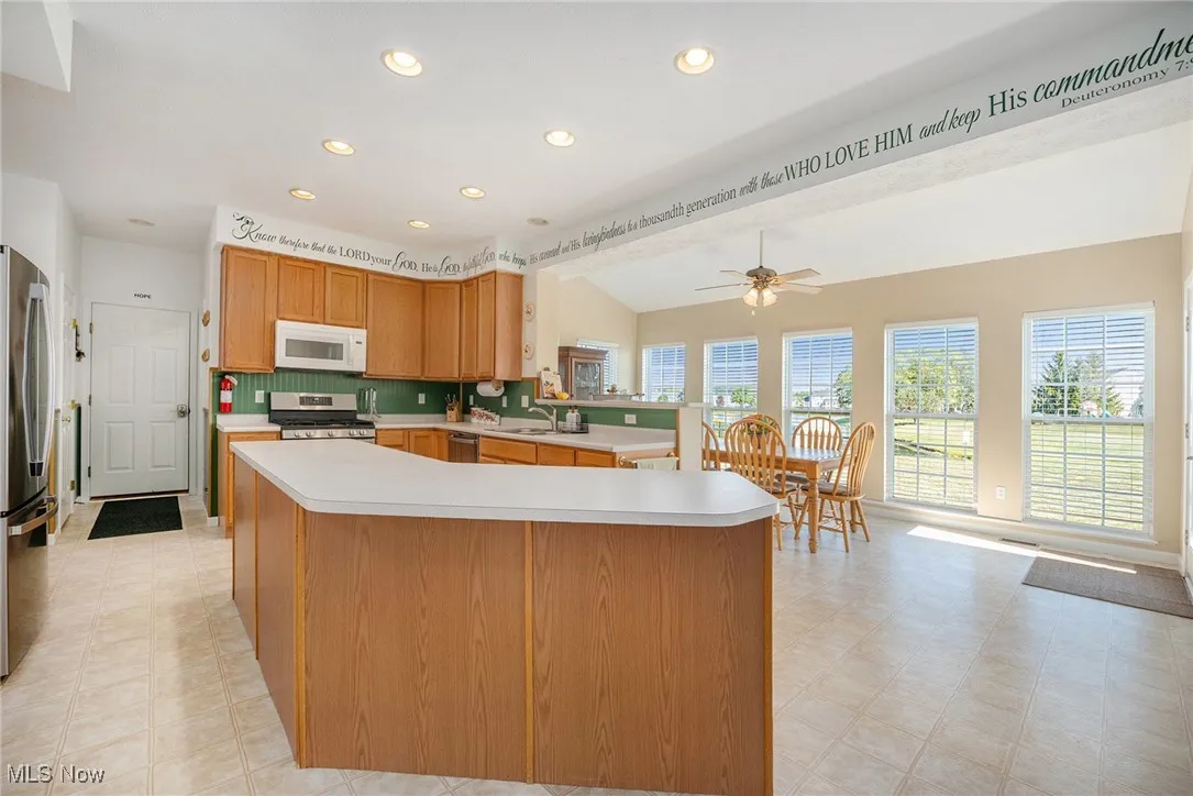 Kitchen featuring light countertops, recessed lighting, appliances with stainless steel finishes, ceiling fan, and light floors