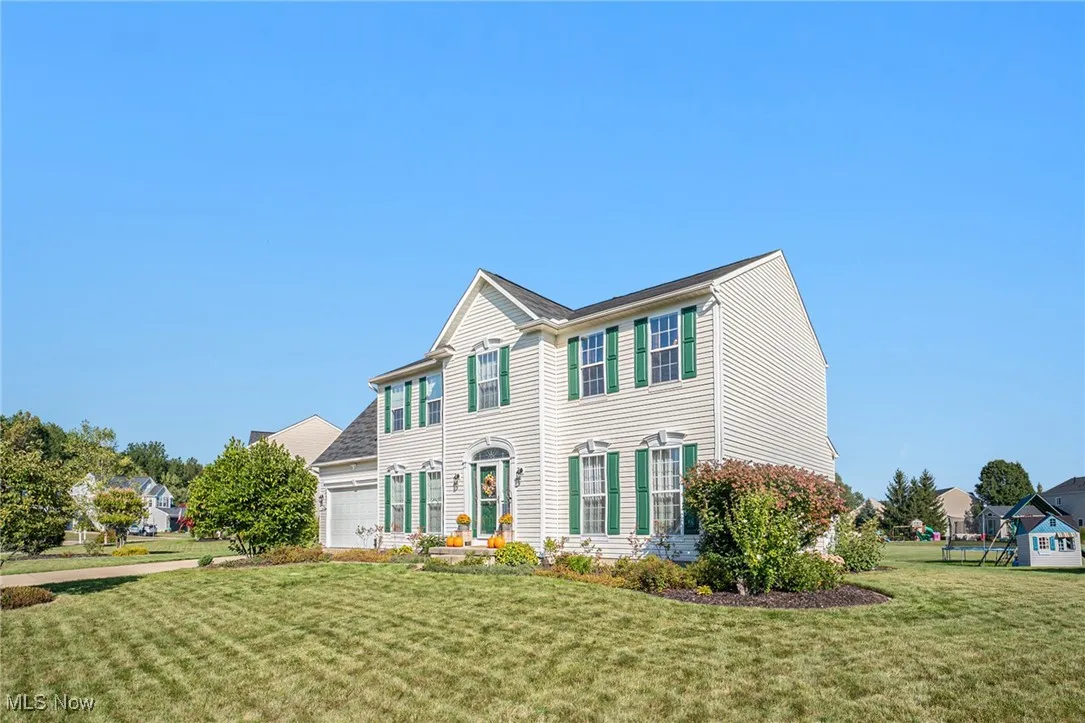 Colonial-style house featuring a front lawn and an attached garage