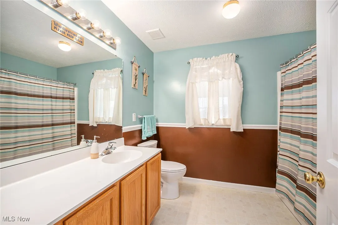 Full bath featuring vanity, a textured ceiling, and a shower with curtain