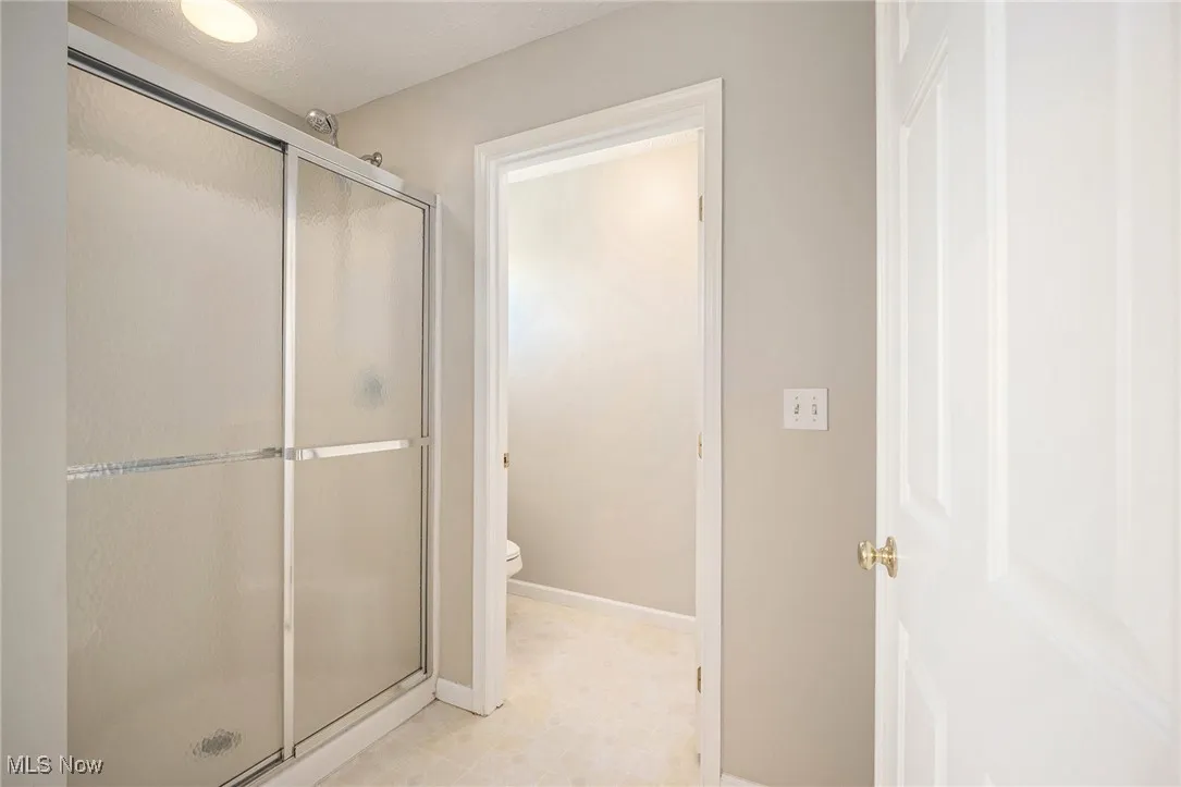 Bathroom with a stall shower and toilet