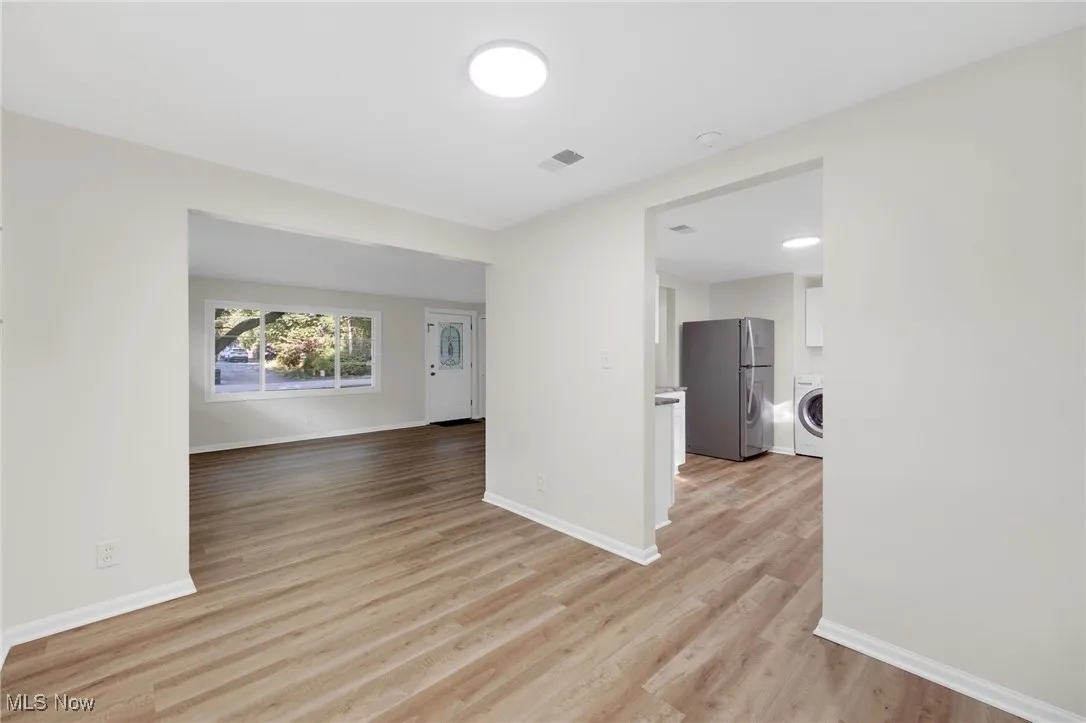 Empty room featuring light wood-style flooring and washer / dryer
