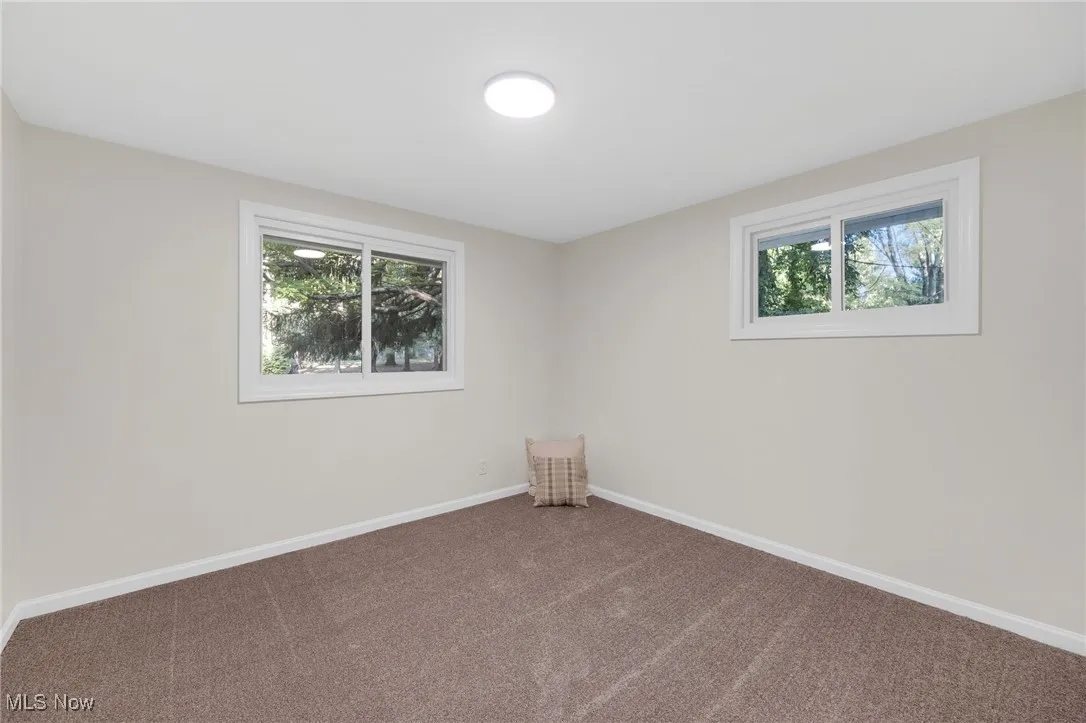 Carpeted spare room featuring baseboards