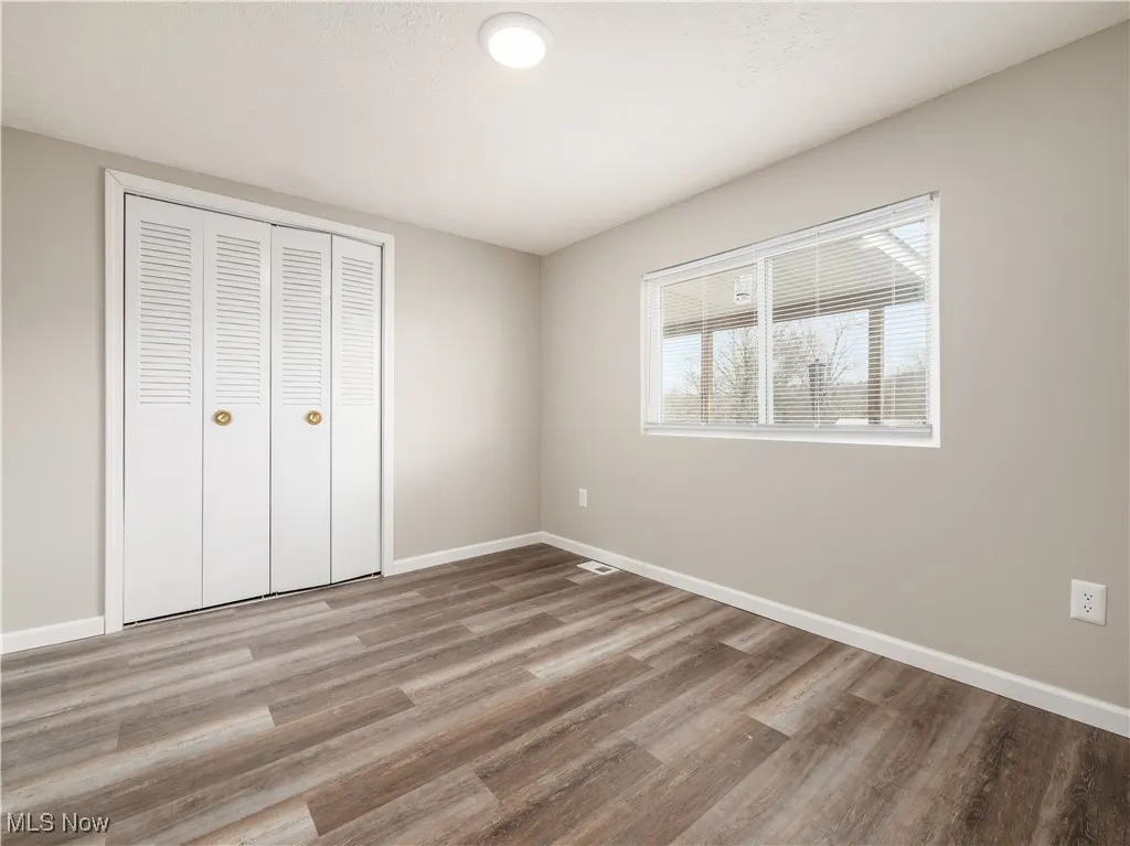 Unfurnished bedroom featuring a closet and light wood-style flooring