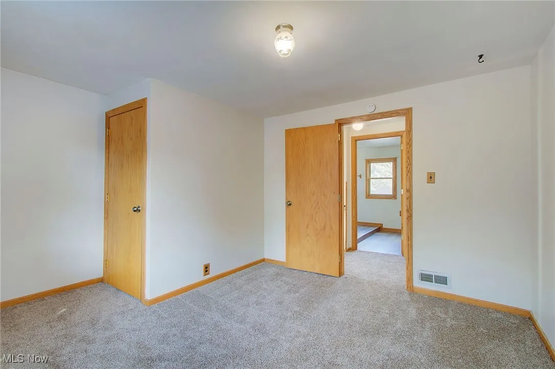 Empty room with carpet floors and baseboards