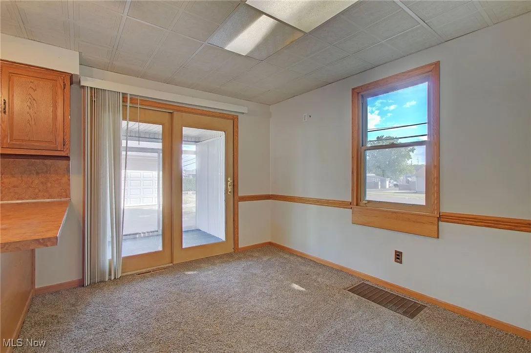 Empty room featuring light carpet and baseboards