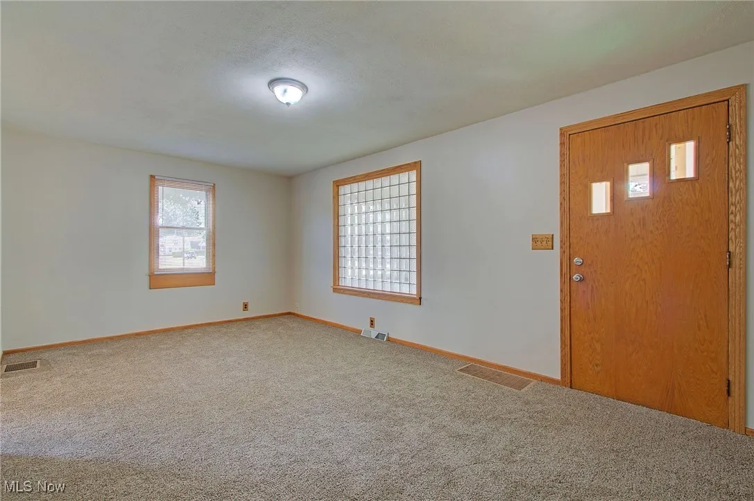 Foyer with baseboards and carpet