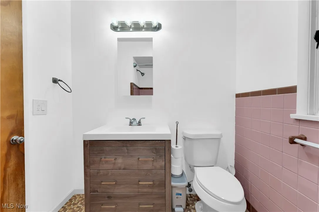 Bathroom featuring vanity and tile walls