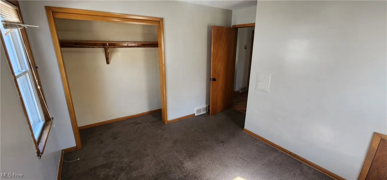 Unfurnished bedroom with carpet flooring and a closet