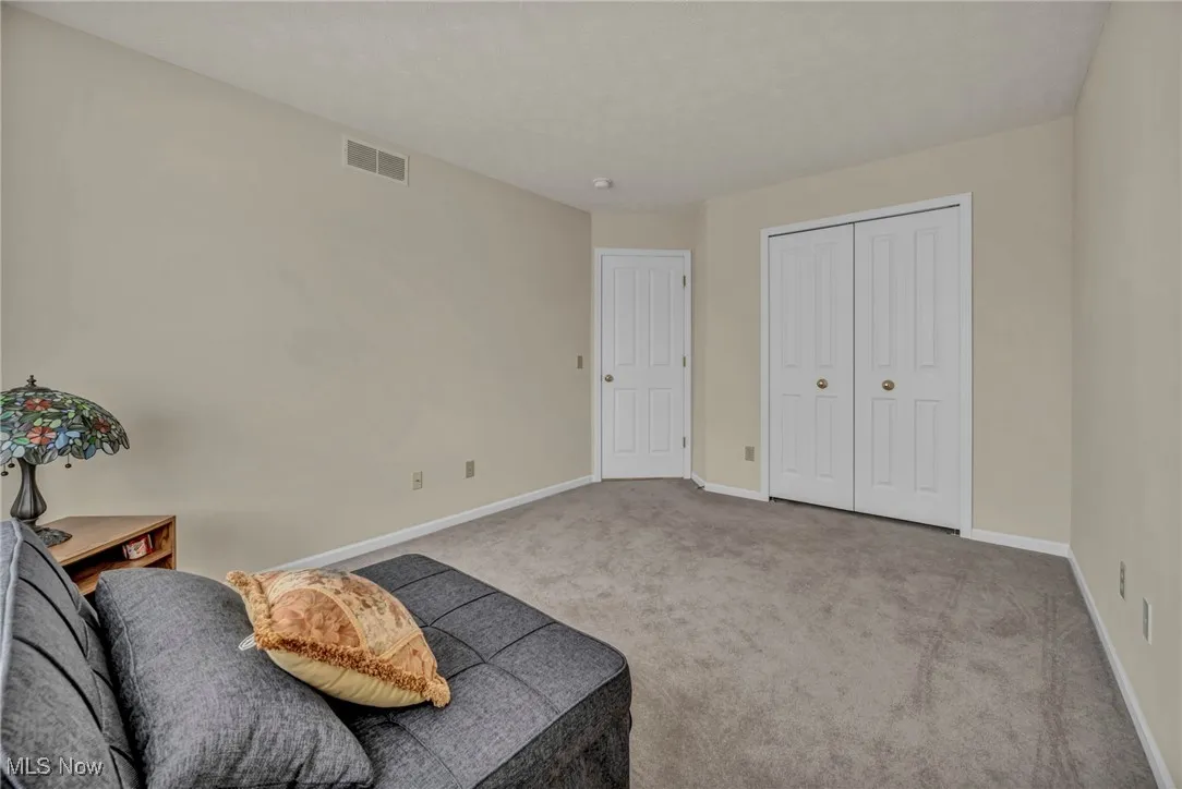 Carpeted bedroom featuring baseboards and a closet