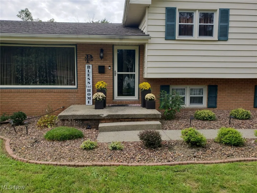 Property entrance with brick siding and a shingled roof