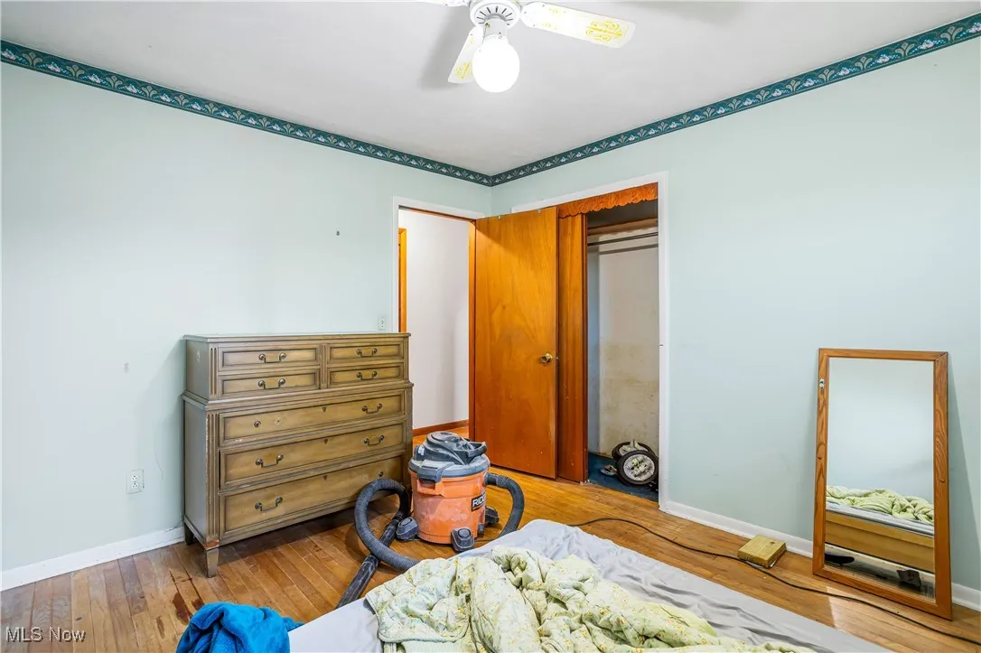 Bedroom with hardwood / wood-style flooring, a closet, and a ceiling fan