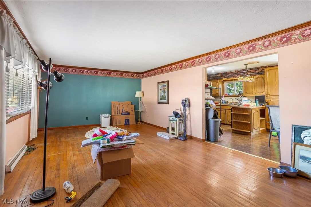 Living area featuring hardwood / wood-style flooring, baseboard heating, and a chandelier