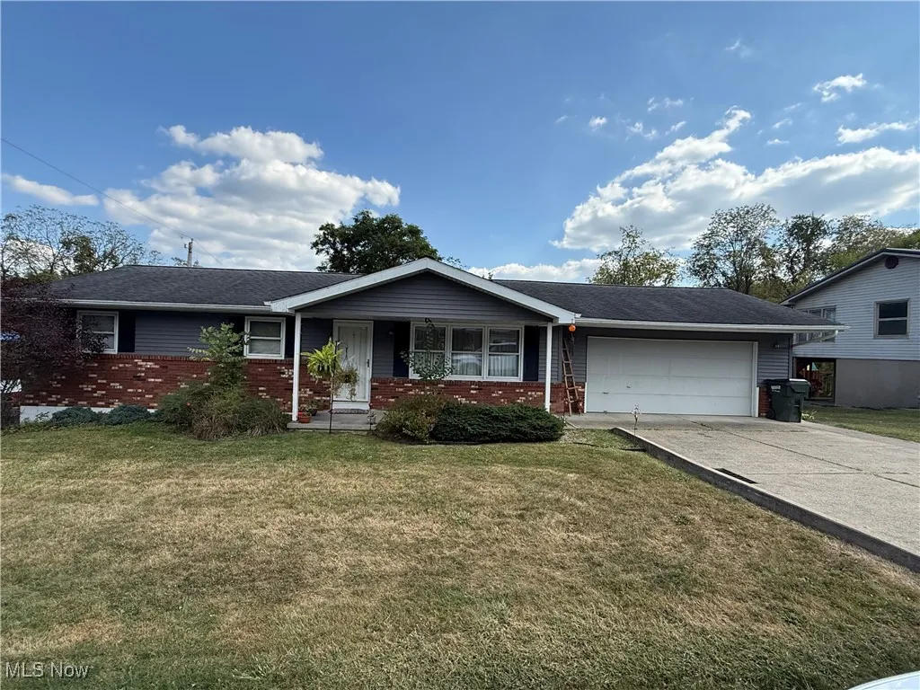 Single story home with brick siding, covered porch, and a front lawn