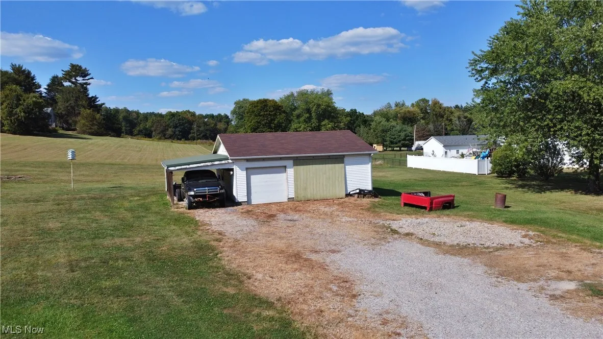 View of outdoor structure with driveway and a carport