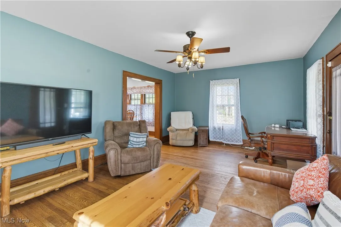 Living area with wood finished floors and ceiling fan