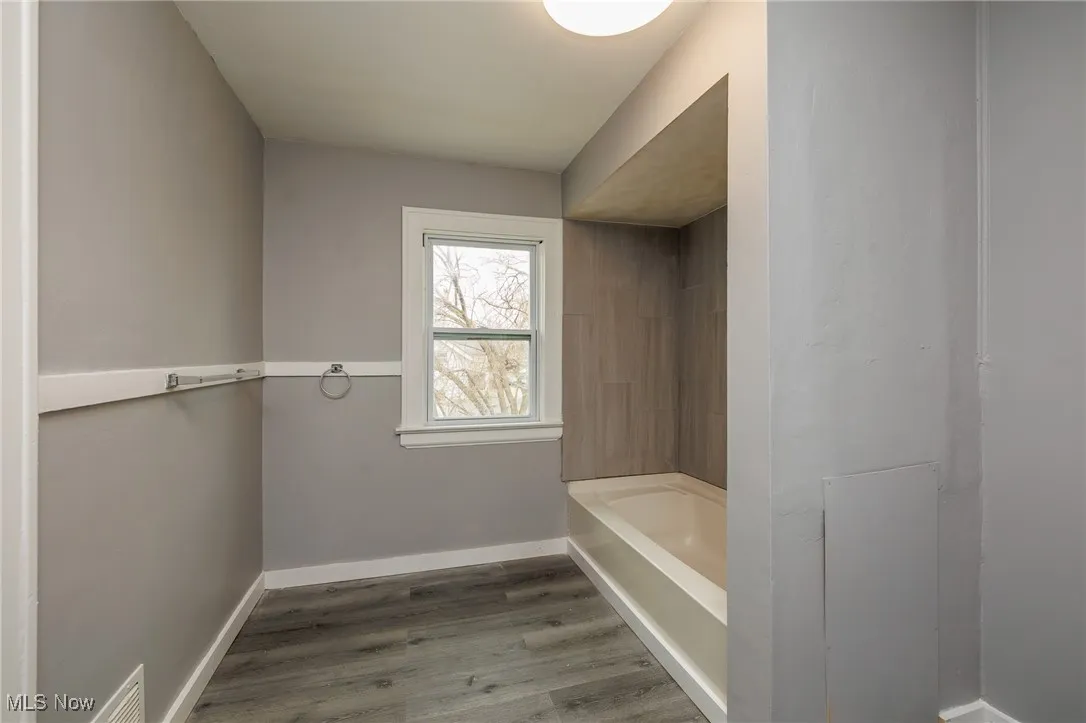Full bath with light wood-style flooring and bathtub / shower combination