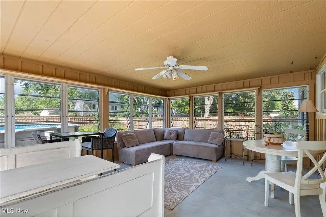 Sunroom / solarium with a ceiling fan, outdoor lounge area, concrete floors, and outdoor dining area