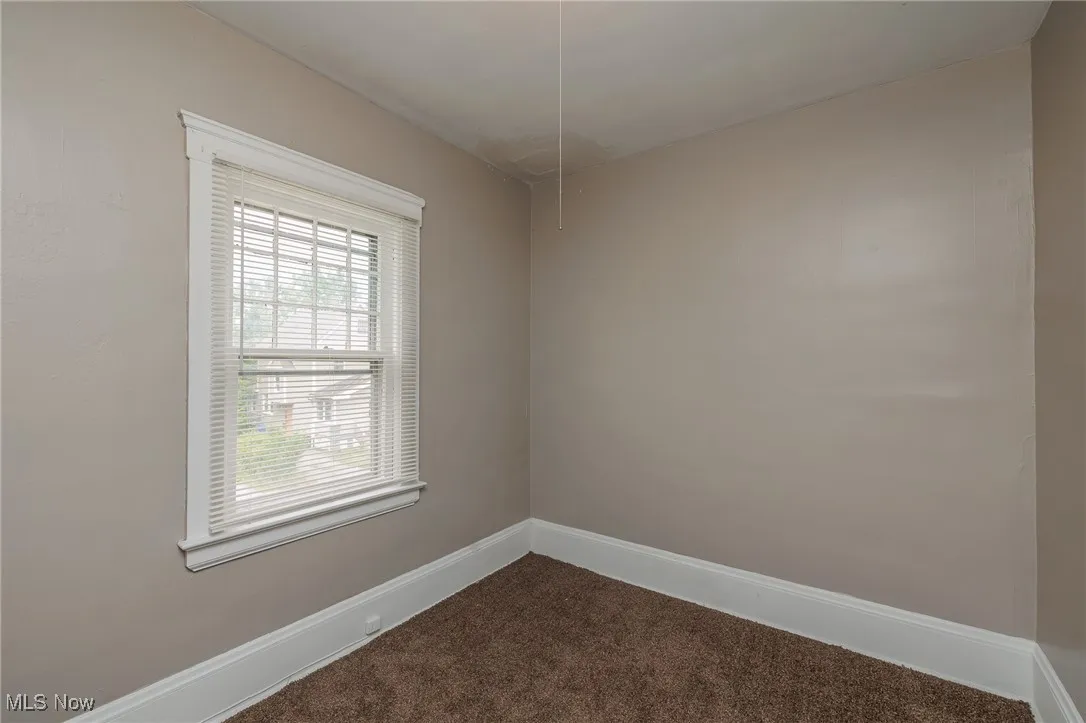 Empty room featuring carpet and baseboards