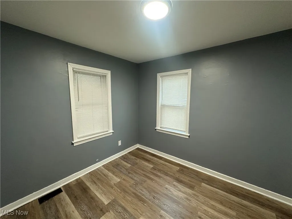 Empty room with baseboards and wood finished floors