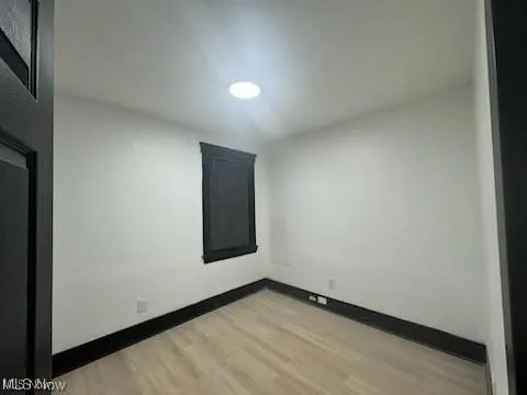 Bedroom featuring light wood-type flooring and baseboards