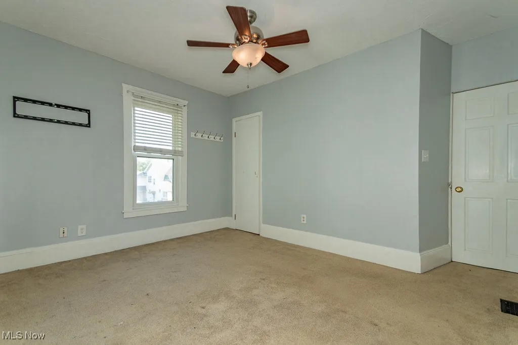 Spare room with light carpet and ceiling fan