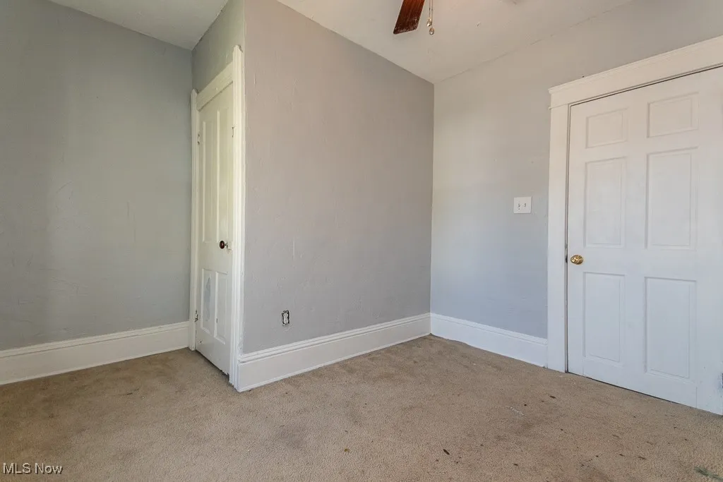 Spare room featuring carpet and a ceiling fan
