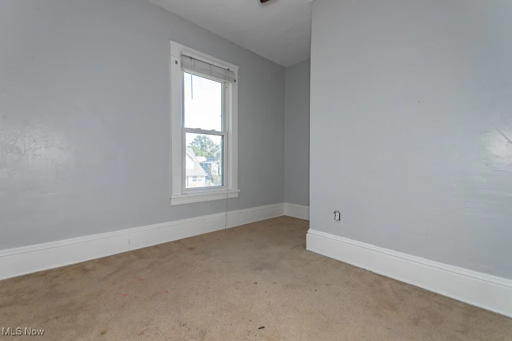 Spare room with baseboards and carpet