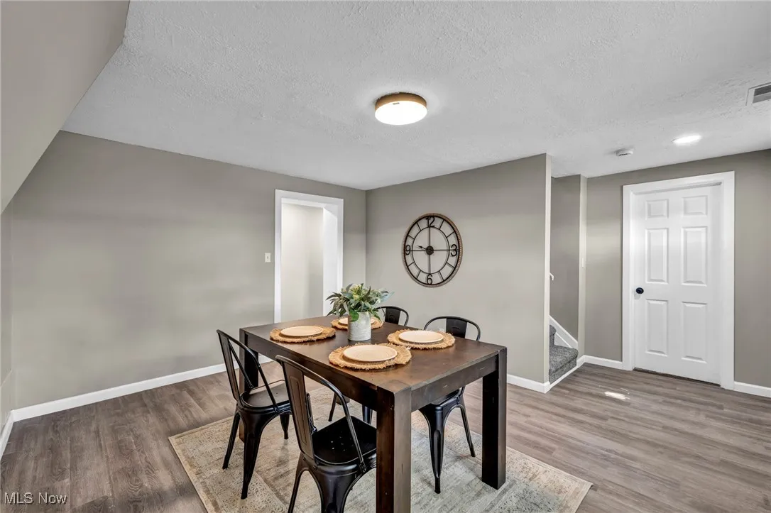Dining area featuring wood finished floors, a textured ceiling, and stairs