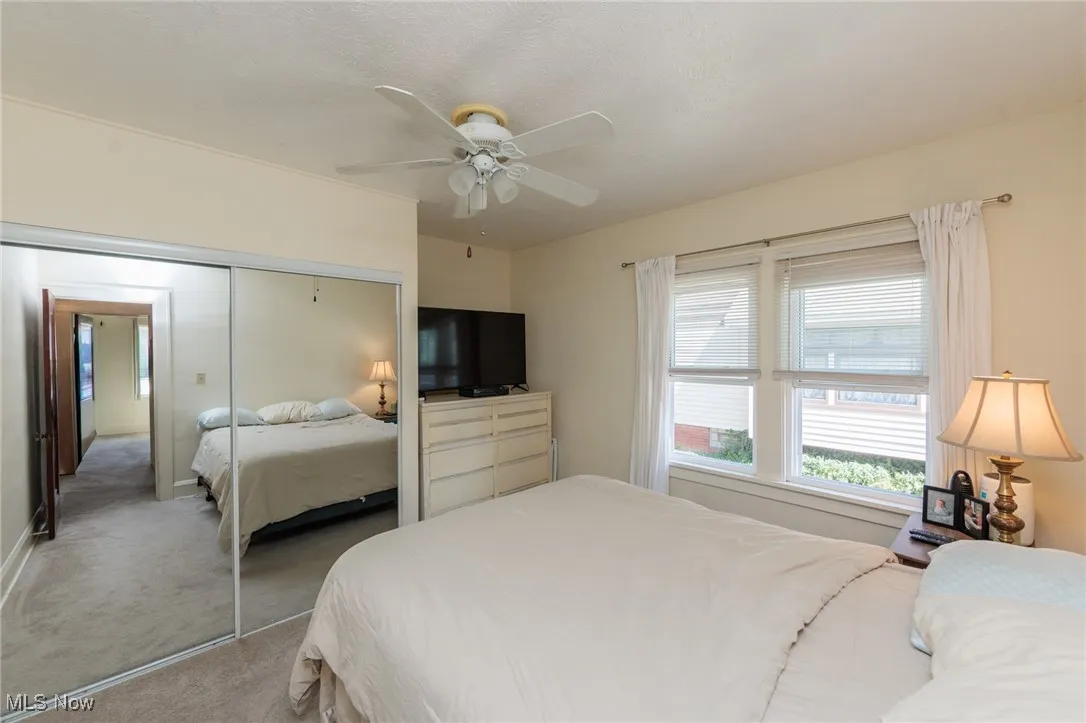 Bedroom with carpet floors, a ceiling fan, a closet, and a textured ceiling