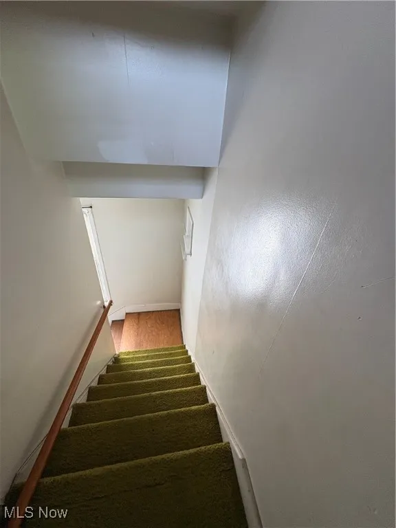 Stairs featuring wood finished floors and baseboards