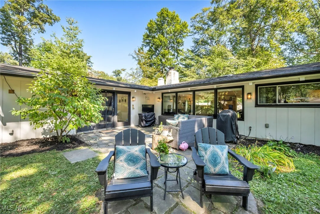 Back of property with a patio, a chimney, a yard, and outdoor lounge area