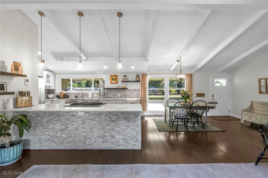 Kitchen featuring open shelves, pendant lighting, decorative backsplash, dark wood finished floors, and white cabinets