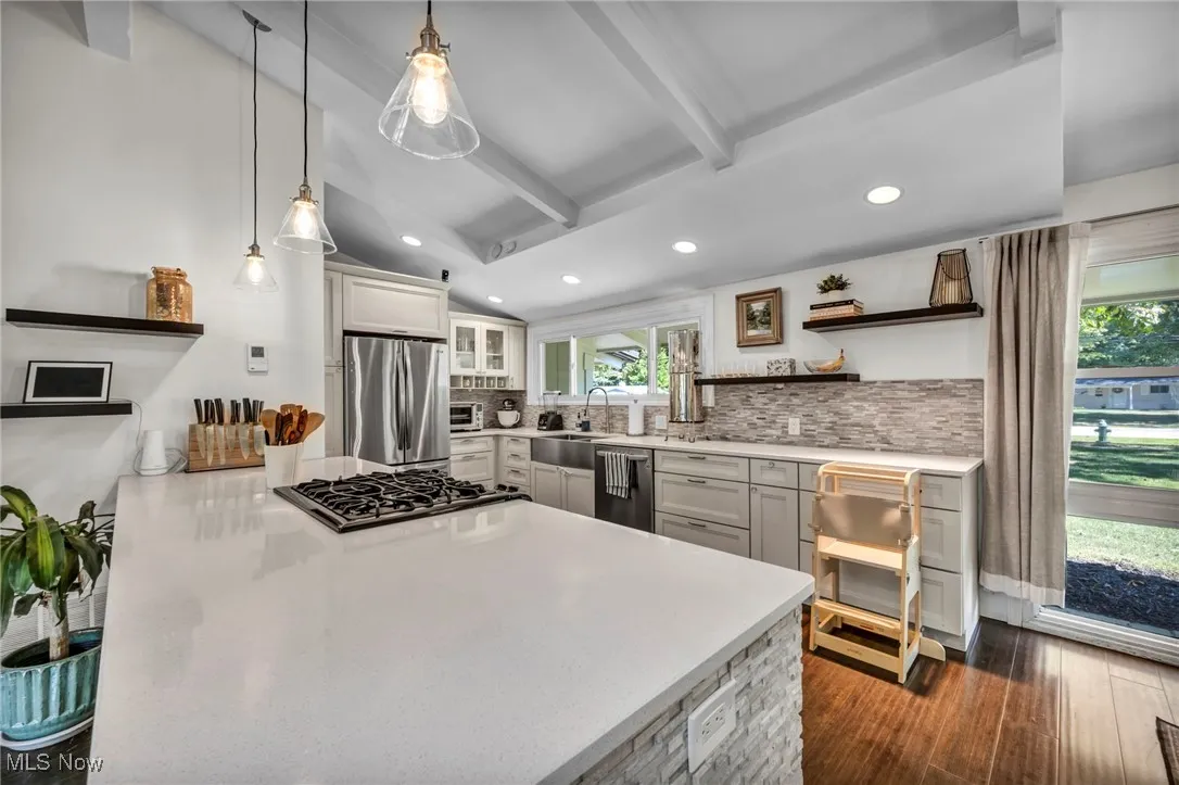 Kitchen featuring open shelves, recessed lighting, backsplash, pendant lighting, and dark wood-style floors