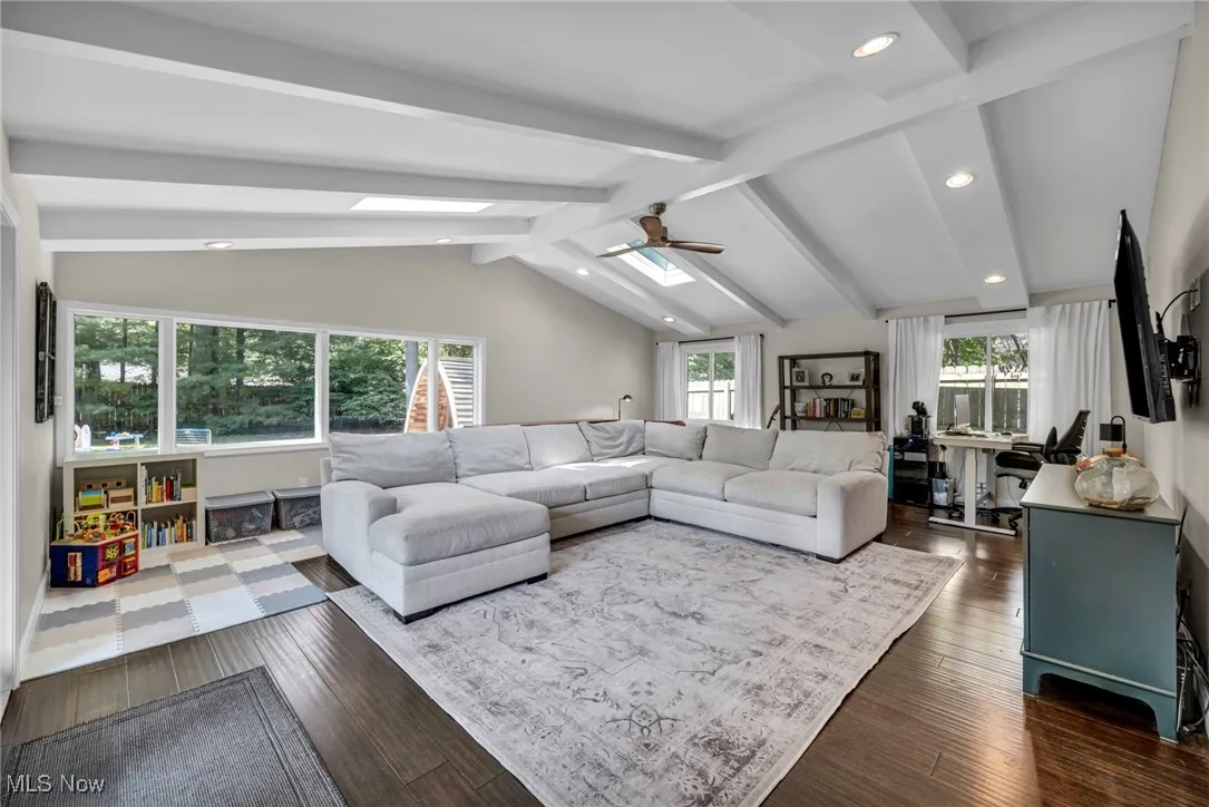 Living area with plenty of natural light, dark wood-type flooring, recessed lighting, and a skylight