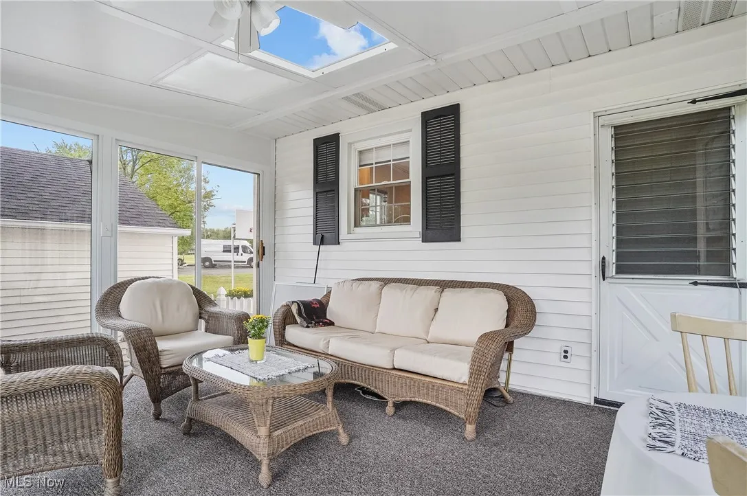 Sunroom / solarium featuring an outdoor living space, a ceiling fan, and a skylight